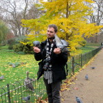 A man in St. James's Park who literally has birds eating from his hands.