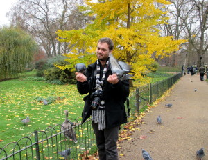 A man in St. James's Park who literally has birds eating from his hands.